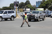 A Johannesburg Metropolitan Police Department (JMPD) officer directs traffic in Fourways, Johannesburg, during load-shedding. 