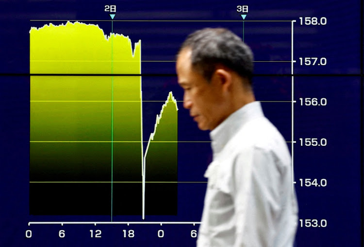 A man walks by an electronic screen displaying a graph showing Japanese yen exchange rates surged against the US dollar, in Tokyo, Japan, May 2 2024. Picture: REUTERS/ISSEI KATO