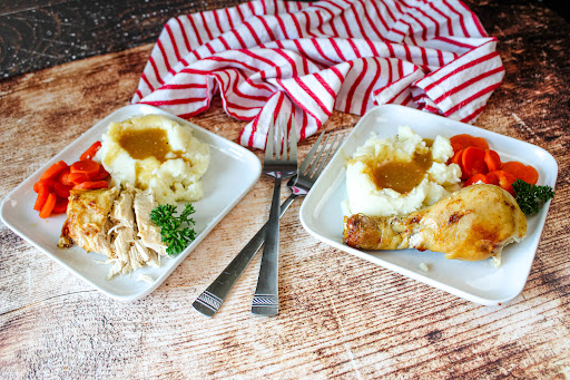 Slow Cooker Work Day Chicken on two plates with side dishes.