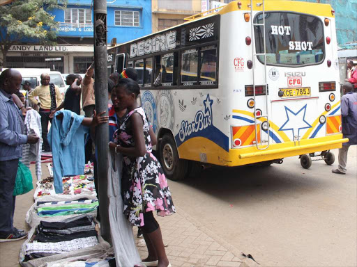 A hawker displays trousers on a Nairobi street