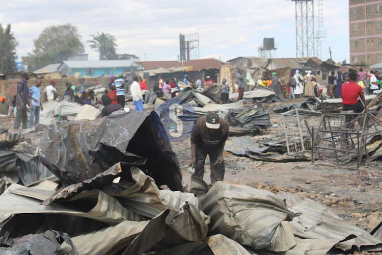 A trader salvaging items after his stall was destroyed by fire at Toi Market in Kibera, Nairobi on June 11,2023.