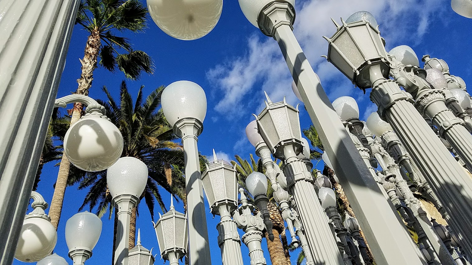 One of the most famous and free (since it is an outdoor sculpture) art you can see in the park at LACMA is the iconic Urban Lights. Created by Chris Burden, it is made of 202 restored street lamps in various styles based on where they were from (most are from southern California and some from Portland Oregon too!). The lamps are painted grey and assembled in a grid, and are solar powered and become lit in the evening.