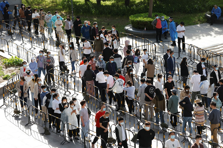 People line up outside a makeshift nucleic acid testing site during a mass testing for the coronavirus disease (COVID-19) in Haidian district of Beijing, China April 26 2022. Picture: REUTERS/CARLOS GARCIA RAWLINS