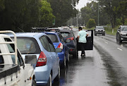 A woman in line at a coronavirus (Covid-19) testing centre steps out of her vehicle to look at the queue of traffic blocking a Western Sydney highway in Sydney, Australia, January 5, 2021.