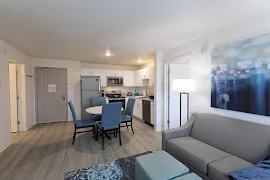 Open concept living room with plush seating, decorative accents, and view of the dining and kitchen area