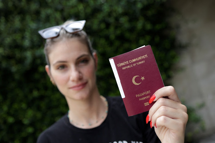 Sinem Okten, a Turkish TV sports presenter, holds her passport during an interview with Reuters in Istanbul, Turkey August 24 2022. Picture: REUTERS/MURAD SEZER