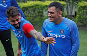 A file photo of India captain Mahendra Singh Dhoni (R) sharing a light moment with current captain  Virat Kohli (L) in Kolkata.  