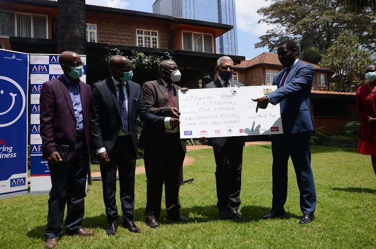 Agriculture CS Peter Munya (right) receives a cheque for Sh117 million insurance payout for farmers from APA officials led by CEO Ashok Shah on August 26, 2020