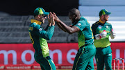 SA captain Faf du Plessis (L) congratulates all-rounder Andile Phehlukwayo after taking a wicket during the second of the five-match ODI series against Pakistan at Kingsmead Stadium in Durban on January 22 2019. 