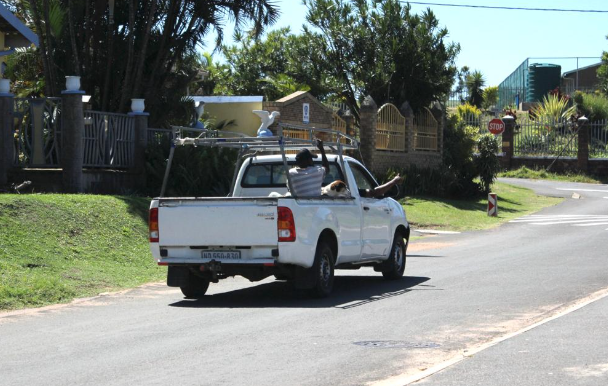 Siyabonga Mkhwanazi on the back of the bakkie with his dog Scott, a mixed breed, leaving after receiving the vaccine.