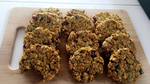 12 Baked Pumpkin Seed Breakfast bars on a wood cutting board.