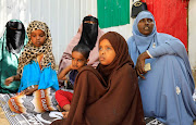 Somali women Ifrah Hilowle Ahmed (R) Khadija Ahmed (C) and Saynab Sheik Ahmed whose sons are missing after they were taken for military training, are seen with their remaining children during a Reuters interview in Mogadishu, Somalia.