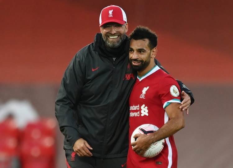 UP THEIR GAME: Liverpool's Mohamed Salah celebrates scoring a hat-trick with the match ball and Liverpool manager Juergen Klopp after the match on September 12 2020