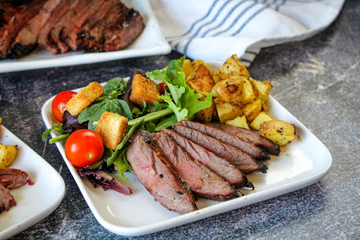 Marinated Flank Steak on a plate with salad.