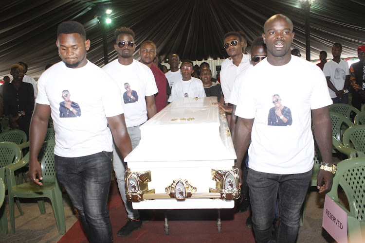 Pall-bearers carry the late Papa Dennis coffin