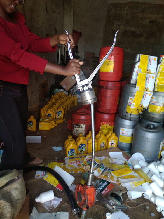 An ACA officer displays the oil filling equipment.