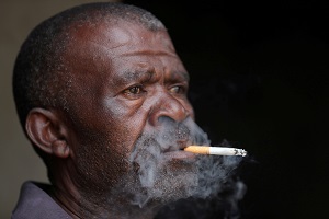 A man smokes a cigarette as South Africa loosens a nationwide lockdown aimed at limiting the spread of the coronavirus disease (Covid-19) in Johannesburg, South Africa August 18, 2020.