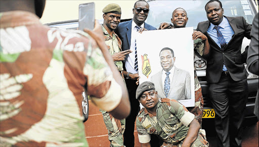 NEW ERA: Members of the military pose with a portrait of Zimbabwe's new president Emmerson Mnangagwa in Harare, Zimbabwe, on Friday Picture: REUTERS
