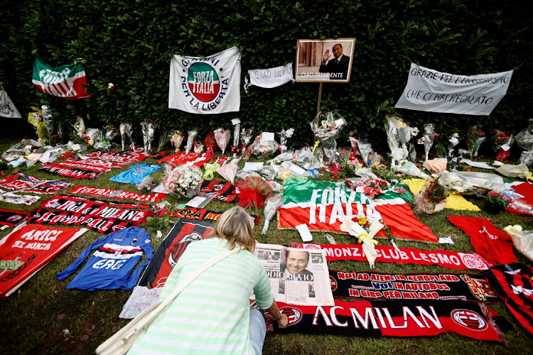 A supporter views tributes to former Italian Prime Minister Silvio Berlusconi outside Villa San Martin in Arcore near Milan, Italy, June 13 2023. Picture: YARA NARDI/REUTERS