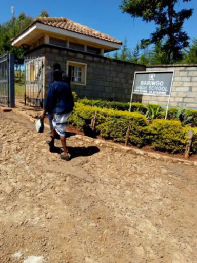 The aggrieved form two student of Baringo High in Eldama-Ravine Sub-County enters school gate with his parent to face school board on Tuesday. /JOSEPH KANGOGO