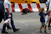 A man lays on the street outside Pennsylvania Station transit hub in New York City, US, June 11, 2021.