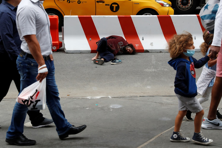 A man lays on the street outside Pennsylvania Station transit hub in New York City, US, June 11, 2021.