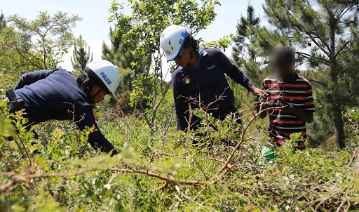 UNHARMED: Two police constables from the East London police Mounted Unit, Merilene Ngunuza and Neziwe Mnqolo, with the 18-year-old whom they found in a bushy area near Mzamomhle township. Picture: ALAN EASON