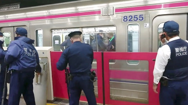 Police officers work at a scene following a knife, arson and acid attack at a Tokyo train line, in Tokyo, Japan October 31, 2021 in this still image obtained from a social media video.