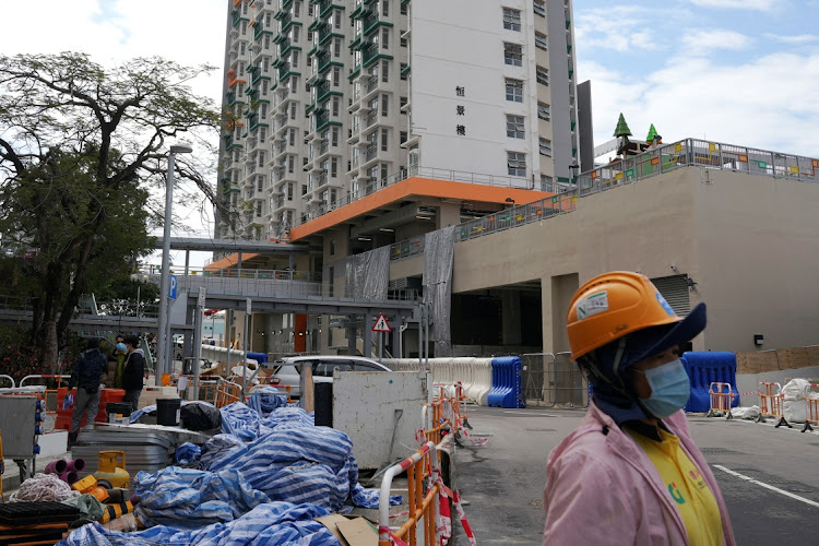 A construction worker stands near a newly built public housing estate that is being converted into a quarantine facility to curb Covid-19 in Hong Kong, China, on February 23 2022.