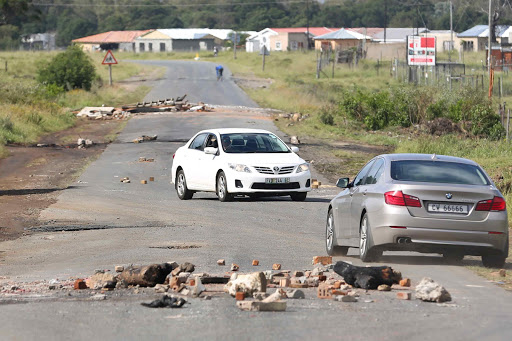 SHARING THE PAIN: Glass and debris lie across Buffalo Pass road obstructing traffic after clashes between police and residents the night before over illegal electricity lines Picture: STEPHANIE LLOYD