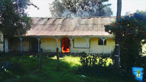 The old building has been set alight as service delivery protests continue in Keiskammahoek. Pucture: ZOLILE MENZELWA