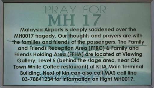 A "Pray for MH17" message is displayed on a flight information board at Kuala Lumpur International Airport in Sepang. Photo credit: Reuters