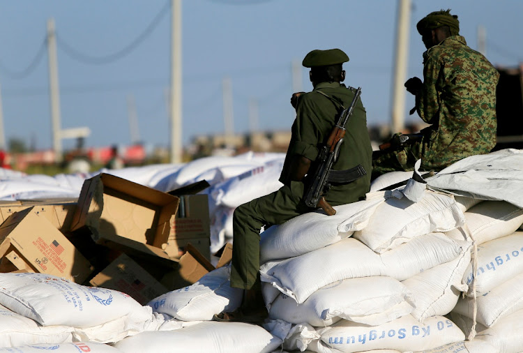 Armed men guard sacks of food delivered to Ethiopian refugees fleeing from the ongoing fighting in Tigray region, at the Fashaga camp, on the Sudan-Ethiopia border, in Kassala state, Sudan on November 24, 2020.