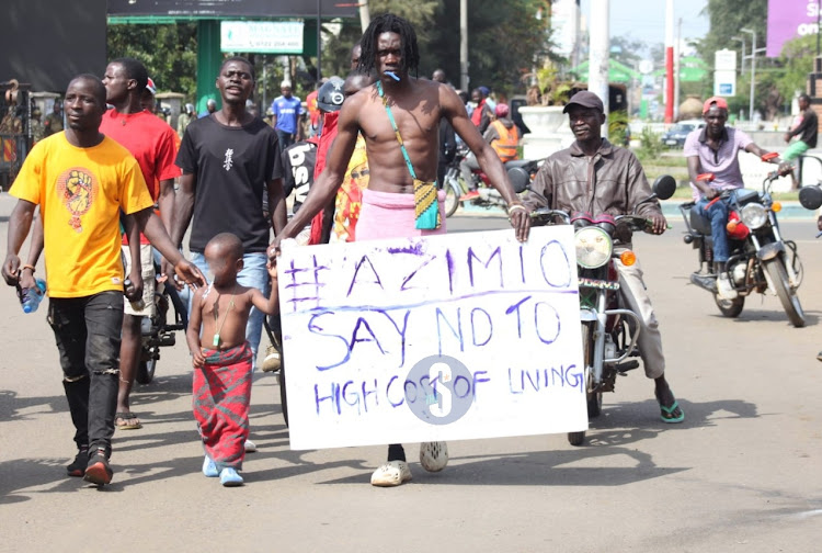 Azimio La Umoja supporter Victor Erick with his three -year-old son Jamal while protesting over high cost of living along Jomo Kenyatta Highway in Kisumu on March 27, 2023.