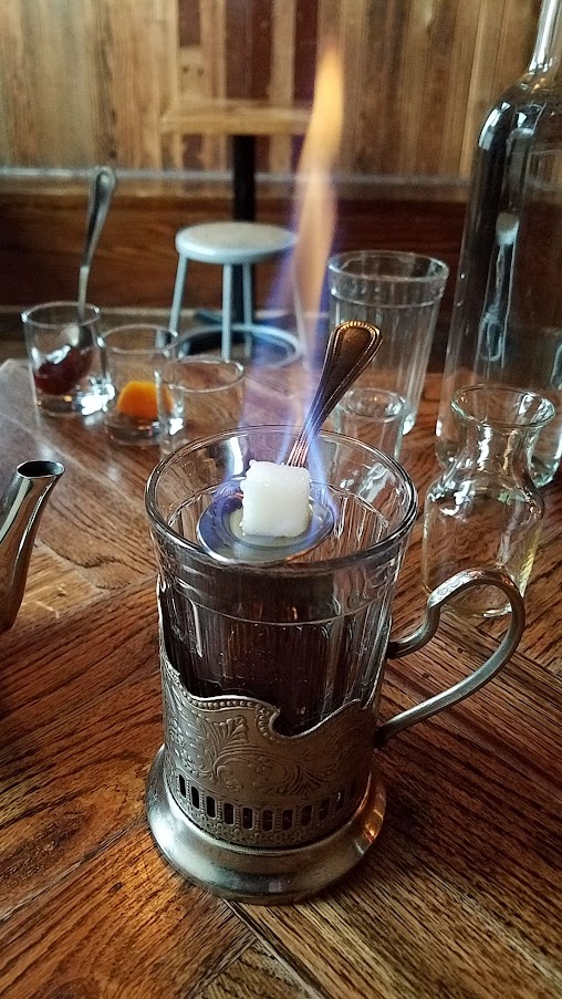 Kachinka Baba Sima's Tonic, which is a version of the hot toddy that includes a bit of tableside show of ingredients. The drink is sweetened with a caramelized cube of sugar lit on fire, a spoonful of jam that you can add to the tea or take small nibbles of as you drink the beverage. The drink is inspired from Chef Owner Bonnie Morales' grandmother's invention