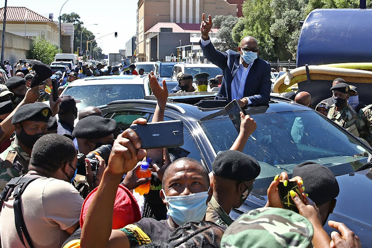 Ace Magashule waving at scores of his supporters moments after appearing at the Bloemfontein magistrate's court.