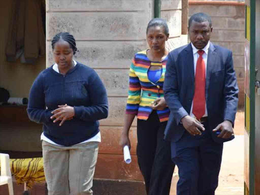 Ann Mbaithe (left) during her arrest for allegedly stabbing her husband to death after he arrived late and drunk at their home in Tinganga village, Kiambu town, July 31, 2016. /STANLEY NJENGA