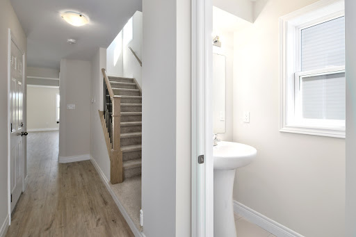 Hallway with stairs and small bathroom in this luxury property for sale in Grey Highlands ($322,856)