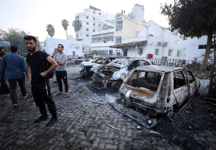 People inspect the area of Al-Ahli hospital where hundreds of Palestinians were killed in a blast that Israeli and Palestinian officials blamed on each other, and where Palestinians who fled their homes were sheltering amid the conflict with Israel, in Gaza City on October 18 2023.