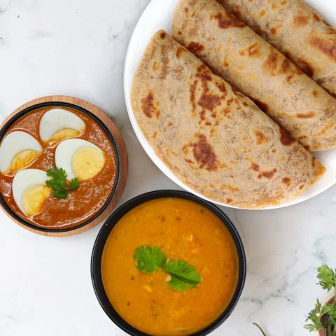 Masala Egg Curry, Yellow Dal Tadka, Paratha Thali