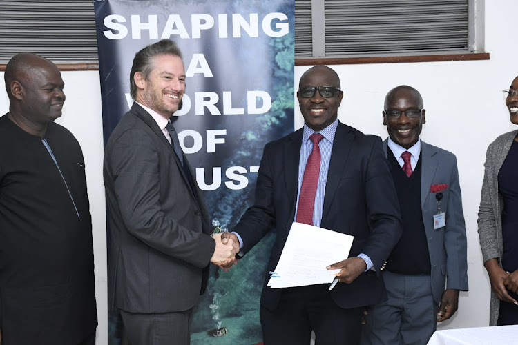 Chief operations officer Brian Ouma watches as France to Kenya Ambassador Arnaud Suquet shakes hands with Eastern Africa District Chief Executive Cyprian Kabis and DVC AA Prof Julius Ogengo representing the Vice chancellor during the landmark agreement between University of Nairobi and French companies on July 3, 2023.