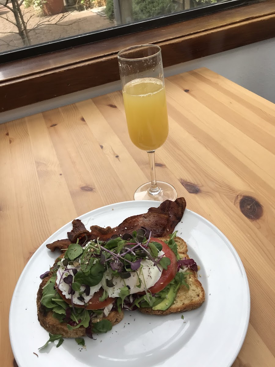 Gluten free avocado toast with an added poached egg and bacon. Drink was the elderflower mimosa! Highly recommend