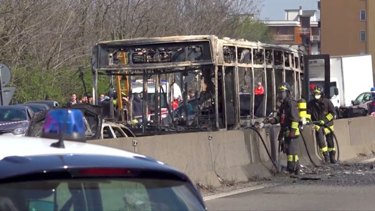 The wreckage of a bus that was set ablaze by its driver in protest against the treatment of migrants trying to cross the Mediterranean Sea, is seen on a road in Milan, Italy, on March 20 2019.