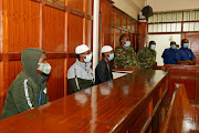 Hussein Hassan, Liban Abdullah Omar and Mohamed Ahmed, suspects charged with helping al Qaeda-linked militants to launch an attack on the Westgate mall, sit in the dock at the Milimani Law Courts in Nairobi, Kenya October 7, 2020. 