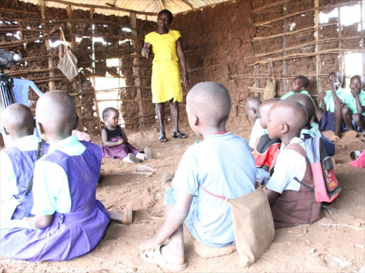 A teacher and pupils during a lesson in a collapsing classroom in Kotuga Primary School, Suna West, Migori/MANUEL ODENY