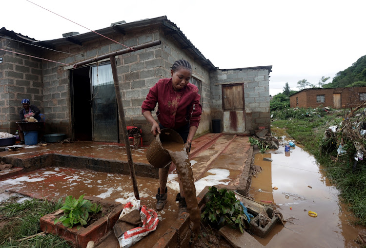 Olwethu Mabhayi, 24, cleans her home after heavy rain in Peace Valley.