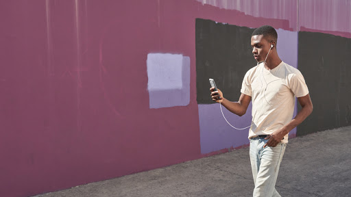 Man walking, using Pixel Buds to listen to Pixel 3