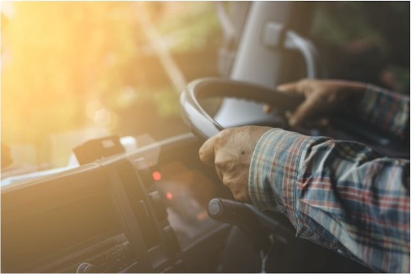 a person with two hands on the wheel in a truck