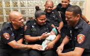 Firefighters from Belhar fire station are reunited with baby Bronlyn-Lee, whom they rescued earlier this month. 