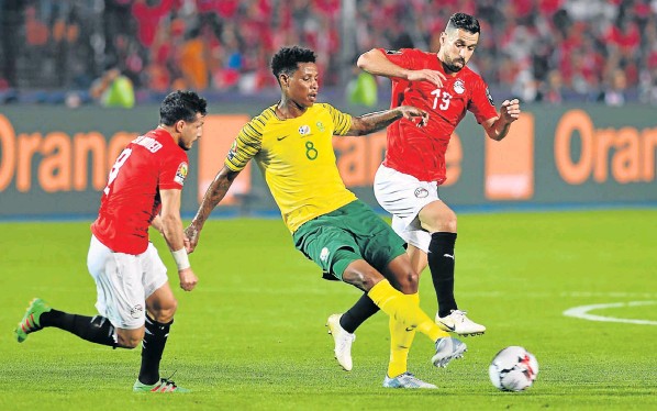 Bongani Zungu, of South Africa, is challenged by Abdallah Said, left, and Tarek Hamed, of Egypt, during their Africa Cup of Nations last-16 soccer clash in Cairo on Saturday